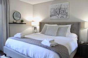 una camera da letto con un grande letto bianco con asciugamani di Free Parking - CHOC and St Joseph's Hospital Adjacent - 1 bedroom Apartment a Santa Ana