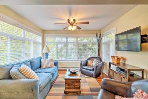 a living room with a blue couch and a ceiling fan at Downtown Charlevoix Duplex half Mi to Lake Michigan in Charlevoix