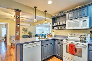 a kitchen with blue cabinets and white appliances at Downtown Charlevoix Duplex half Mi to Lake Michigan in Charlevoix