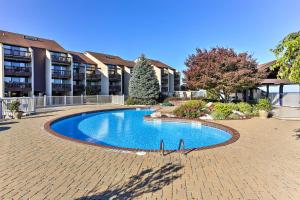 a swimming pool in front of a building at The Shores Condo with Beach Access Less Than 2 Mi to Dtwn! in Port Clinton
