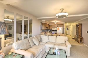 a living room with a white couch and a kitchen at The Shores Condo with Beach Access Less Than 2 Mi to Dtwn! in Port Clinton