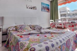 una camera da letto con un letto con una trapunta sopra di Olimpia 3 a Playa de las Americas