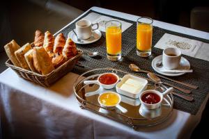 - une table de petit-déjeuner avec un plateau de pain et du jus d'orange dans l'établissement Hôtel U Palazzu & Spa, à Venaco