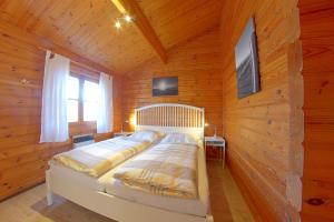 ein Schlafzimmer mit einem Bett in einer Holzhütte in der Unterkunft Ferienhaus Nordsee in Dorum Neufeld