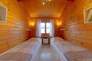 - une chambre avec 2 lits dans une cabane en rondins dans l'établissement Ferienhaus Nordsee, à Dorum Neufeld