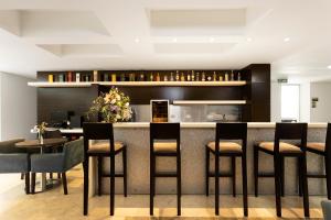 a kitchen with a bar with stools at Hotel bh Bicentenario in Bogotá +46 photos