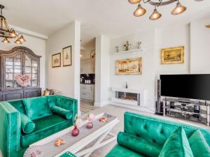 uma sala de estar com mobiliário verde e uma televisão de ecrã plano em Lovely Apartment Near Town Center em Folkestone