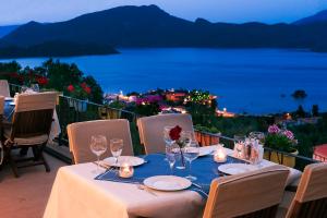 a table with wine glasses and a view of the ocean at Swan Lake Hotel - Adult Only in Selimiye