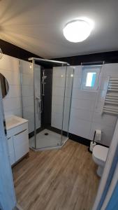 La salle de bains est pourvue d'une douche et de toilettes. dans l'établissement Top Alex domki Międzyzdroje, à Międzyzdroje