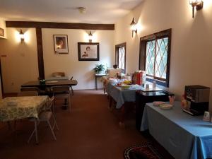 una habitación con mesas y sillas y un ordenador portátil sobre una mesa en Kancamagus Swift River Inn en Albany