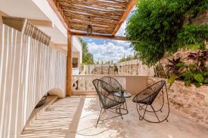 un patio con 2 sillas y una mesa en Hotel Colonial Zaci by GuruHotel en Valladolid