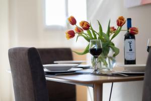 a table with a vase of flowers and a glass of wine at Helios Residence in Chania Town