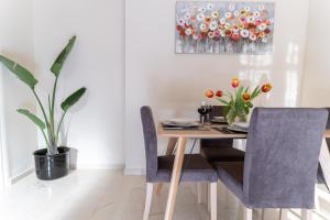 a dining room table with two chairs and a vase with flowers at Helios Residence in Chania