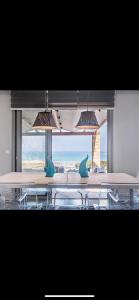una stanza con tavoli e sedie con vista sull'oceano di Villa Aegina a Khlóï