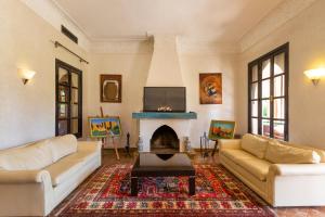 a living room with two couches and a fireplace at Villa Thaifa in Marrakesh
