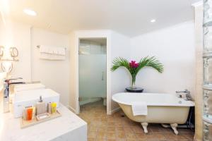 
a white bath tub sitting next to a white sink at Coco Palm in Gros Islet
