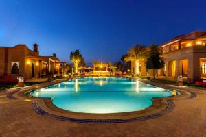 a large swimming pool in a courtyard at night at Villa Thaifa in Marrakesh