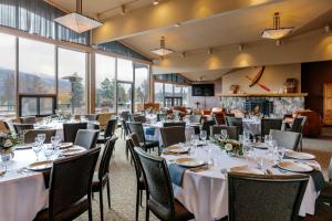 une salle à manger avec des tables, des chaises et une cheminée dans l'établissement Lobstick Lodge, à Jasper