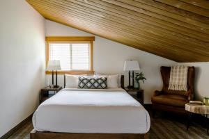 a bedroom with a bed and a chair at Pyramid Lake Lodge in Jasper