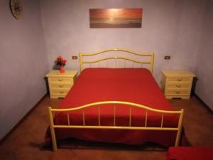 um quarto com uma cama com um cobertor vermelho e 2 cómodas em Podere Leporino em Sarteano