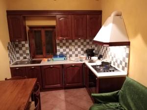 uma cozinha com armários de madeira e um forno com placa de fogão em Podere Leporino em Sarteano