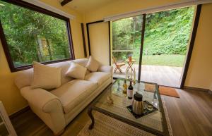 Las Mercedes Lodge في كالي: غرفة معيشة مع أريكة وطاولة زجاجية