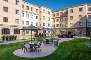 a patio with tables and chairs in front of a building at Staybridge Suites Eau Claire - Altoona, an IHG Hotel in Altoona