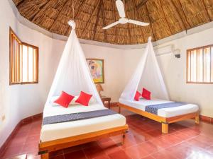 two beds in a room with a ceiling at Hotel Villas del Ángel in San José