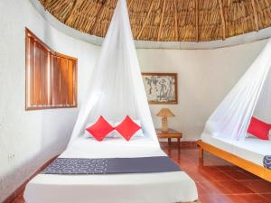 a bedroom with two beds with red pillows at Hotel Villas del Ángel in San José