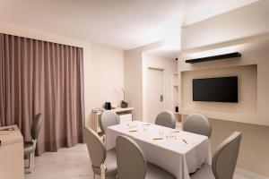 a dining room table with chairs and a television at Nobile Hotel Copacabana Design in Rio de Janeiro