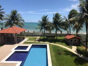 a swimming pool with a view of the beach at Ampla Casa na beira mar de Maragogi in Maragogi