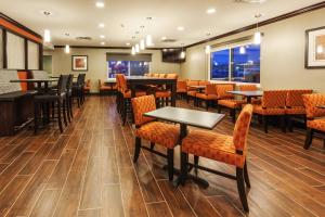 un comedor con mesas, sillas y ventanas en Holiday Inn Express & Suites Rapid City, an IHG Hotel en Rapid City