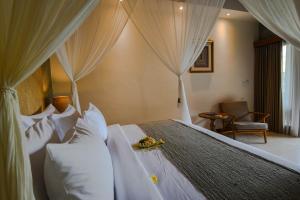
a hotel room with a bed and a canopy at Purana Suite Ubud in Ubud
