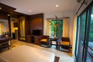 a living room with a table and chairs and a television at Sang Serene House in Chiang Mai