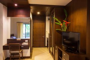 a living room with a television and a table with a plant at Sang Serene House in Chiang Mai
