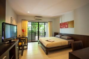 a bedroom with a bed and a flat screen tv at Sang Serene House in Chiang Mai