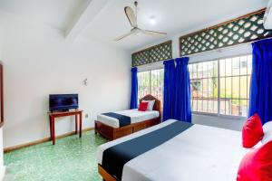 a hotel room with two beds and a tv at Hotel Adelita in Zihuatanejo