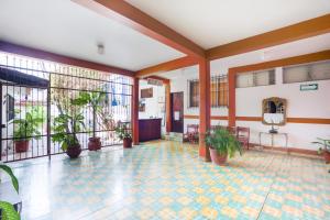 a lobby with a tile floor and plants at Hotel Adelita in Zihuatanejo