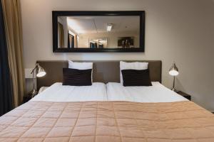 セイナヨキにあるホテル ソルサペサのベッドルーム(大型ベッド1台、大きな鏡付)