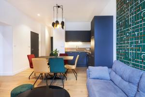 a living room with a blue couch and a table at Résidence Colonel in Laval