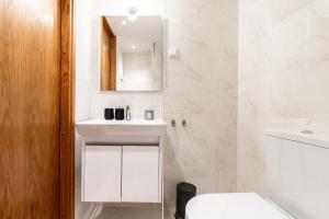 a white bathroom with a sink and a mirror at Dream Stay - Modern City Centre Lofts with Self Check-in in Tallinn +29 photos