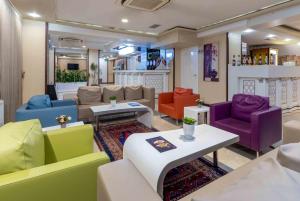 a living room with colorful chairs and tables at Dies Hotel in Diyarbakır