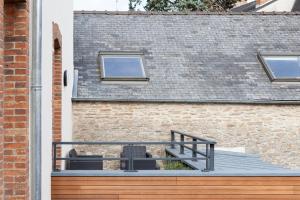 een terras met twee stoelen in een bakstenen gebouw bij Résidence Solférino in Laval