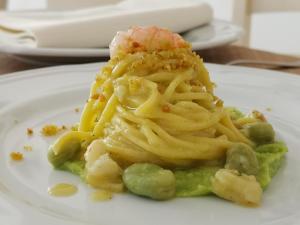 un plato blanco con un trozo de pasta y guisantes en Le Nicchie Guest House, en Lucera