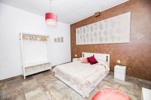 Un dormitorio con una cama con almohadas rojas. en Casa Raffadali, in centro storico a Palermo, en Palermo