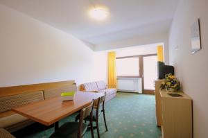 een hotelkamer met een tafel en een bank en een kamer bij Appartments Kameriot in Braies +35 foto's