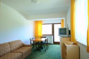 een woonkamer met een bank en een tafel bij Appartments Kameriot in Braies