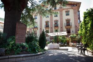 un edificio con una mesa y una sombrilla delante de él en Palacio Azcárate Hotel en Ezcaray