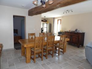 cocina y comedor con mesa de madera y sillas en gîte " L'Albizia", en Prissac