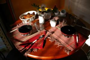 une table en bois recouverte d'un tissu de table rouge avec une assiette de nourriture dans l'établissement Mas Uranie, à Le Soler